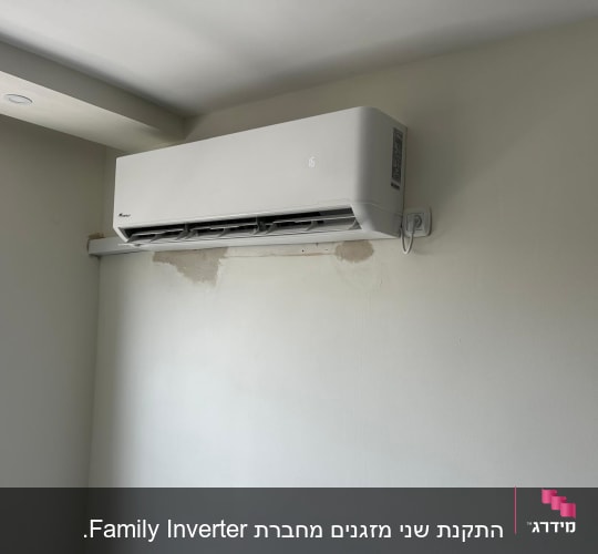 מזגן מותקן על קיר לבן עם שלט חשמלי
